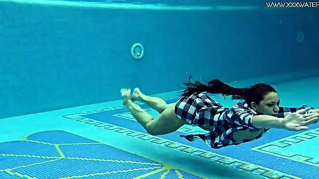 Beauty jumps in the pool and strips to swim naked