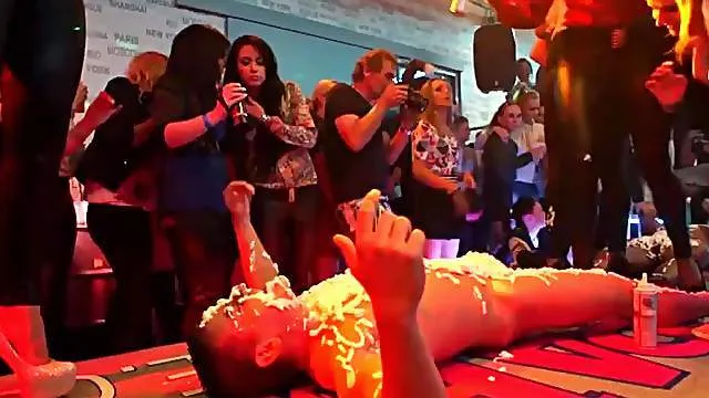 Ladies lick whipped cream off a male stripper