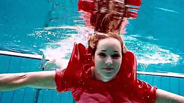 Teen swimming in her red satin prom dress