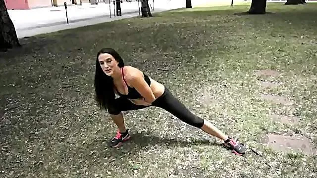 Sporty milf in skimpy workout clothes in a public park