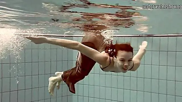Elegant girl swimming in her pretty dress