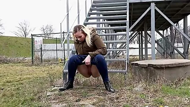 Blonde drops her pants to piss in the grass outdoors