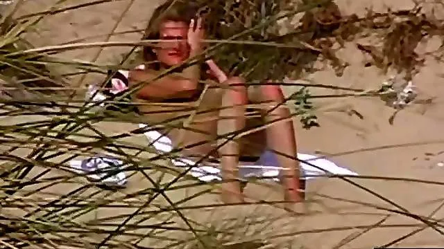 Naked chick at the beach chats on the phone