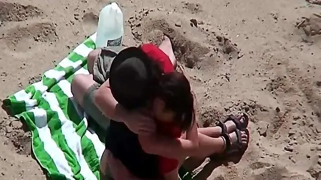 Kissing and tit sucking on the beach with a couple
