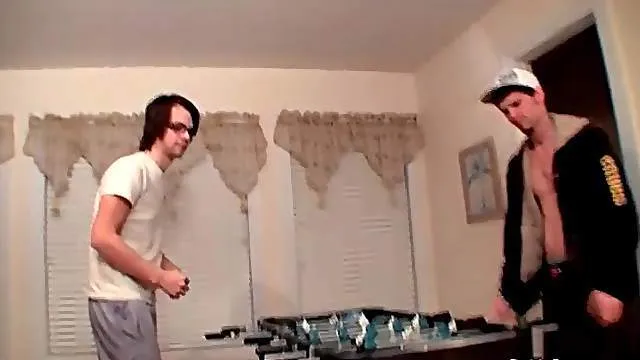 Guys strip as they play foosball