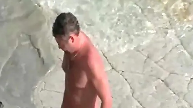 Blonde sits on cock on rocky beach