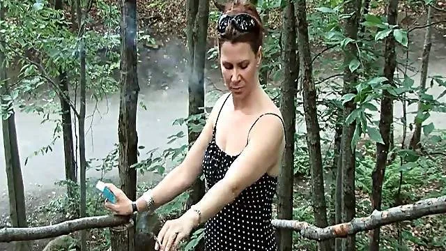 Pretty girl blows smoke rings in the woods