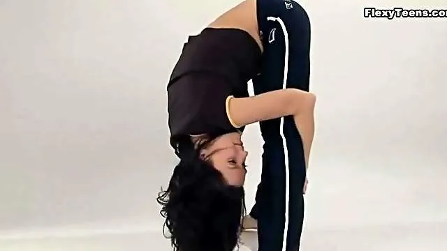 Sporty babe bends her body and strips