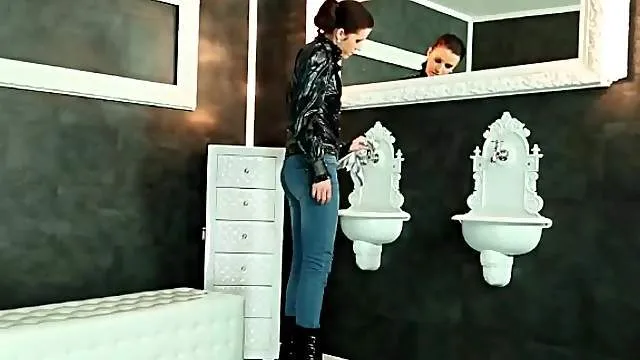 Beauty in blue jeans sucks a toy in the bathroom