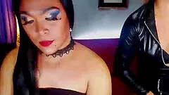 Two lesbian shemales in sexy outfits wanking their cocks and stripping in front of camera