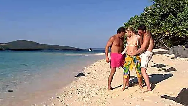 Two guys fuck a blonde at the beach