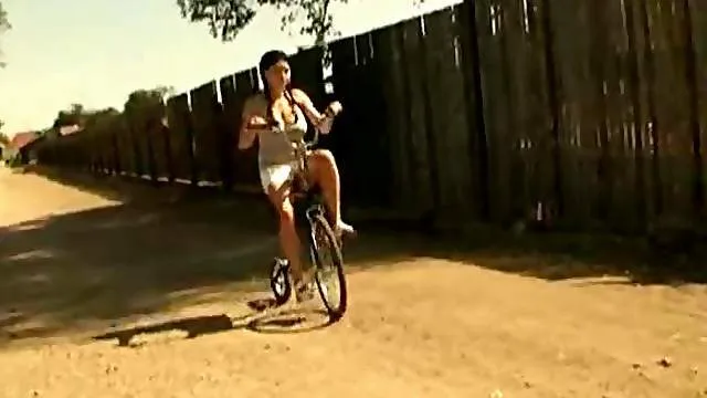 Girl in pigtails riding her bike naked
