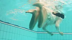 Delicious babe dives into the pool and strips down completely