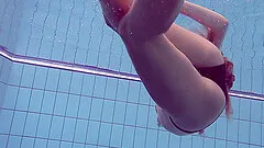 Seductive Russian filly Lucy Gurchenko swims in the pool while naked