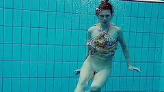 Ravishing redhead babe with a nice ass strips down underwater