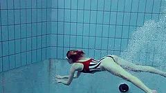 Skinny Russian babe dives into the pool and strips down