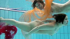 Two delicious babes fool around in the pool while being naked