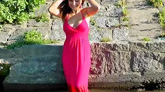 Cleavage bearing babe in a red dress playing in the water