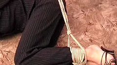 Completely clothed Russian slim woman has her hands and feet tied up