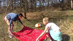 Playful teens in a grassy field love the taste of pussy