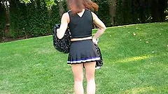 A cute cheerleader flashes her tits while in her uniform