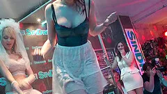 Girls in a club climb up on the stage and get wet in a shower