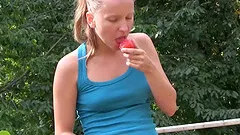 Playing with her shaved pussy on a nice day outside