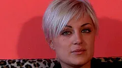 A girl with tattoos on her feet rubs her toes while having a smoke