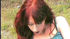 A sexy amateur redhead shows off her feet while reading outside