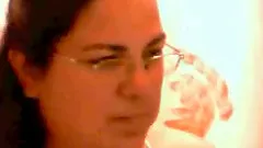 Chubby brunette wearing glasses shows her natural boobs