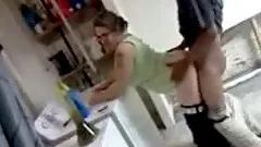 Amateur blond wearing glasses enjoys interracial rear sex in a kitchen