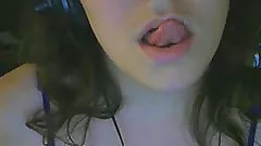 Brunette chick licks her lips in front of a webcam