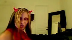 Bitch in a devil costume performs in front of a webcam