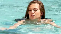 Petite brunette Subil Arch enjoys fingering her pussy in the pool