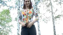 Slim brunette shows her tits and enjoys golden rain in the park