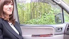 A nice Japanese girl in office clothes gives head in a car