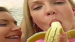 Two slim blondes suck a banana and lick each other's shaved vags