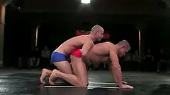 Oiled up guys fight on the mat and have wild anal sex
