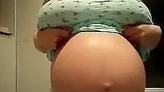 Busty pregnant chick shows off her tits and huge belly for the cam