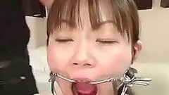 Japanese girl gets mouth-fucked by two men in a BDSM video