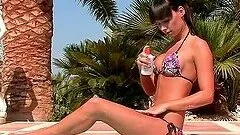 Petite brunette chick masturbates by the poolside
