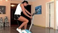 Sporty brunette girl fingers her pussy after workout