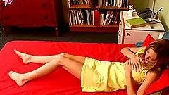Skinny girl masturbates lying on a red sofa