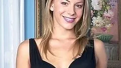 Smiling blonde lies on the sofa and toys her pussy with a dildo