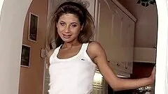 Skinny brown-haired girl plays with a dildo in the doorway