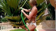Two cute girls play with a water hose and make lesbian love outdoors