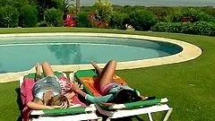 Two oiled girls having lesbian fun by the poolside