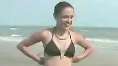 Slim and slender brunette gets naked at the beach