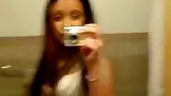 Naughty brunette solo peeing in the toilet and touching