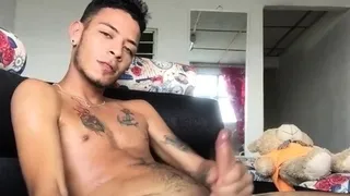 Inked slim Latino masturbates on couch
